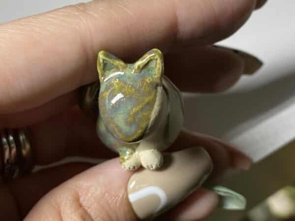 tiny green and white pottery cat
