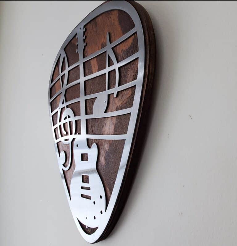 Metal art wall decor guitar pick on rustic wood back ground