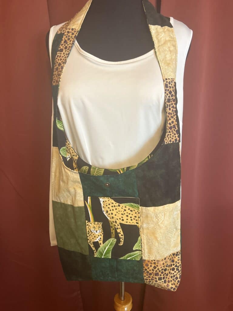 This hippie bag is the perfect carry all for everyday use. Features a 2" wide strap that can be worn over the shoulder for comfort and style. The boho purse measures 36" long from the top of the strap to the base of the purse. The purse body is 16" x 16." This boho purse is fully lined in a patchwork pattern of cotton fabrics in shades of yellow and black. Pockets on each side made of leopard print upholstery fabric.