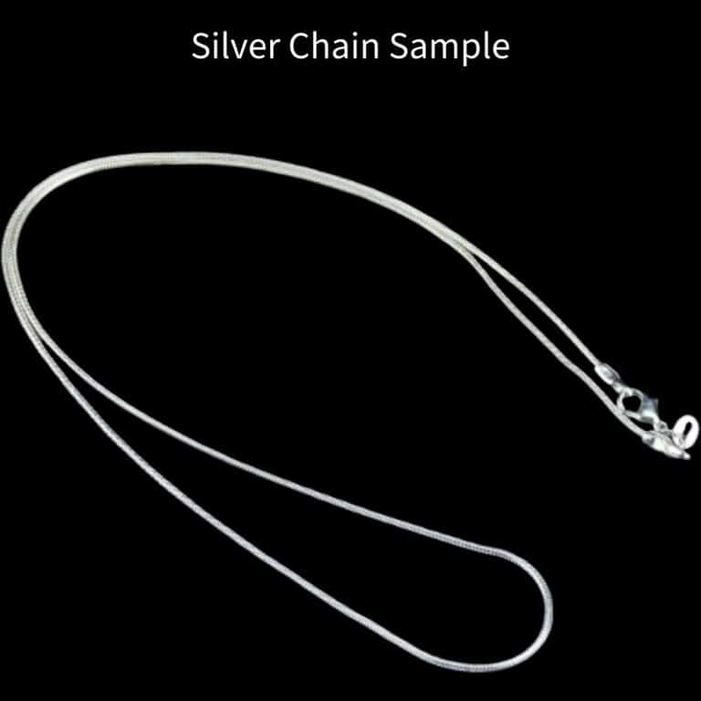 Silver chain laying on a black background