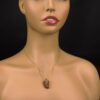 Goldstone pendant with gold chain displayed on a mannequin.