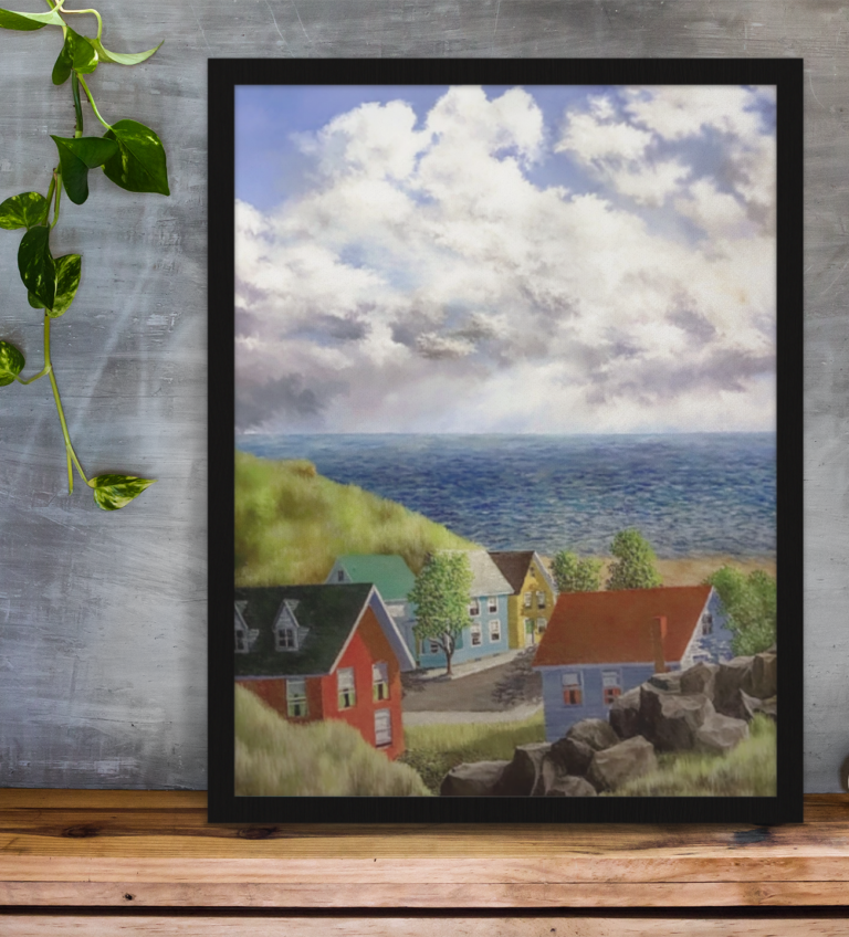 framed art print standing on a wooden desk against a concrete wall near a hand decoration a10403