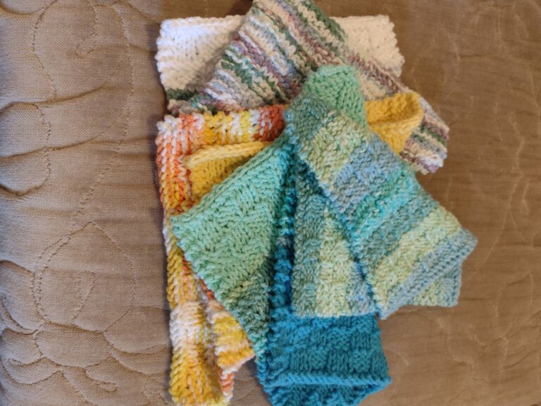 Variety of multi-colored, hand knit, cotton clothes