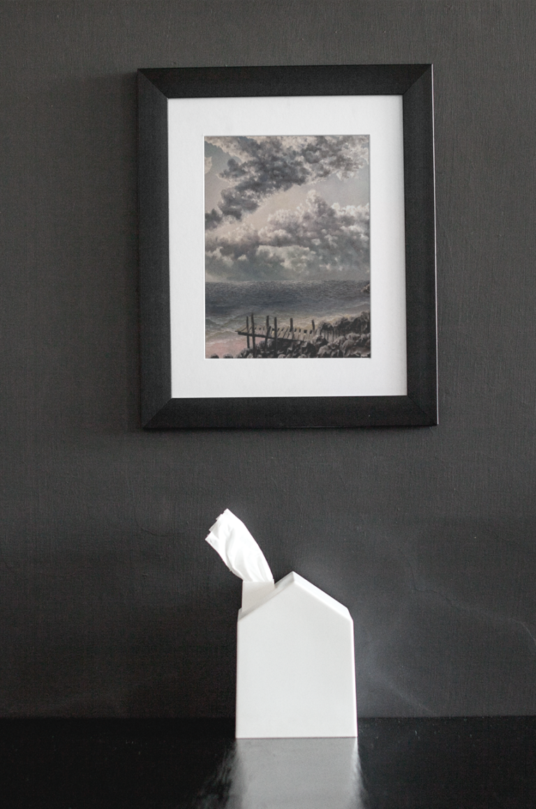 framed art print mockup on a black wall over a black table a14688