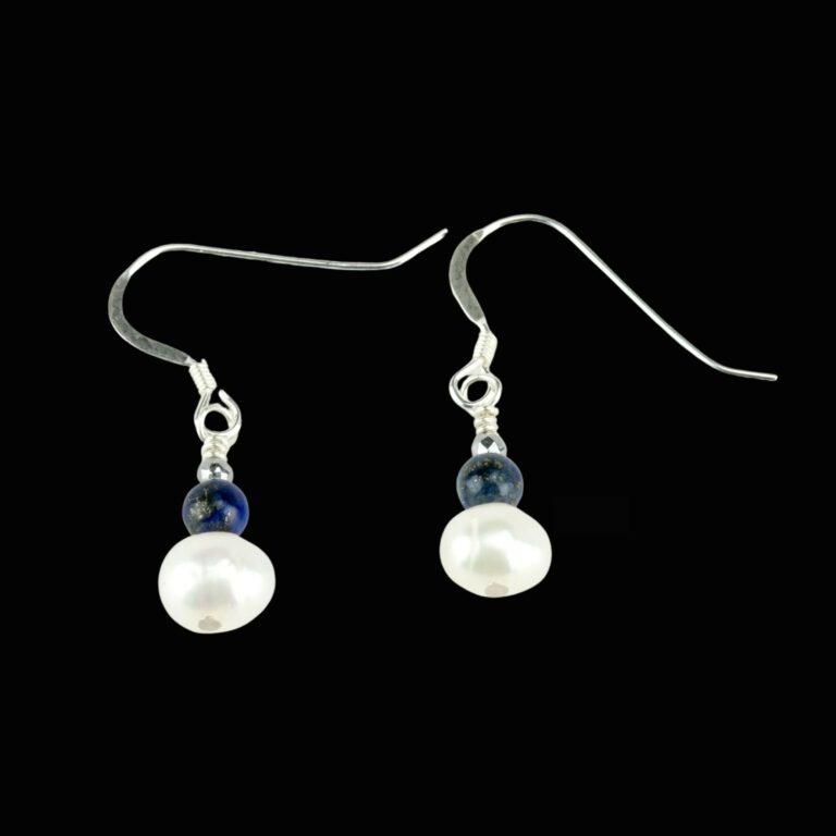 Natural pearl earrings accented with small blue gemstone beads. The earrings have silver ear wires.