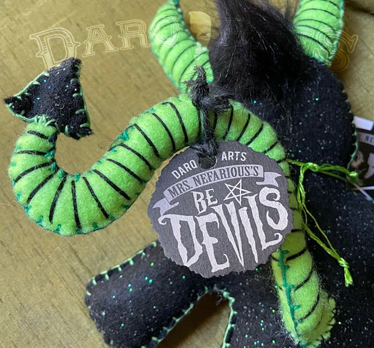 Bedevils. Name Pewtrid. Sparkle black felt body with bright green accents. Back view close up.