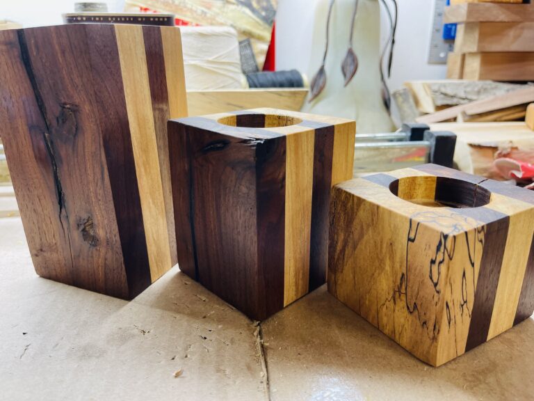 set of three wood candleholders showing wood grain and figures