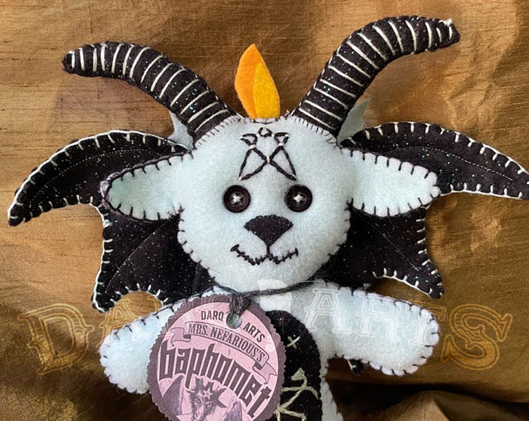 Baphomet front view close up showing adorable soft felt poppet handmade by Mrs. Nefarious of Darq.arts. Aqua body with sparkle black wings, horns and tummy. Eternal flame on top of head.