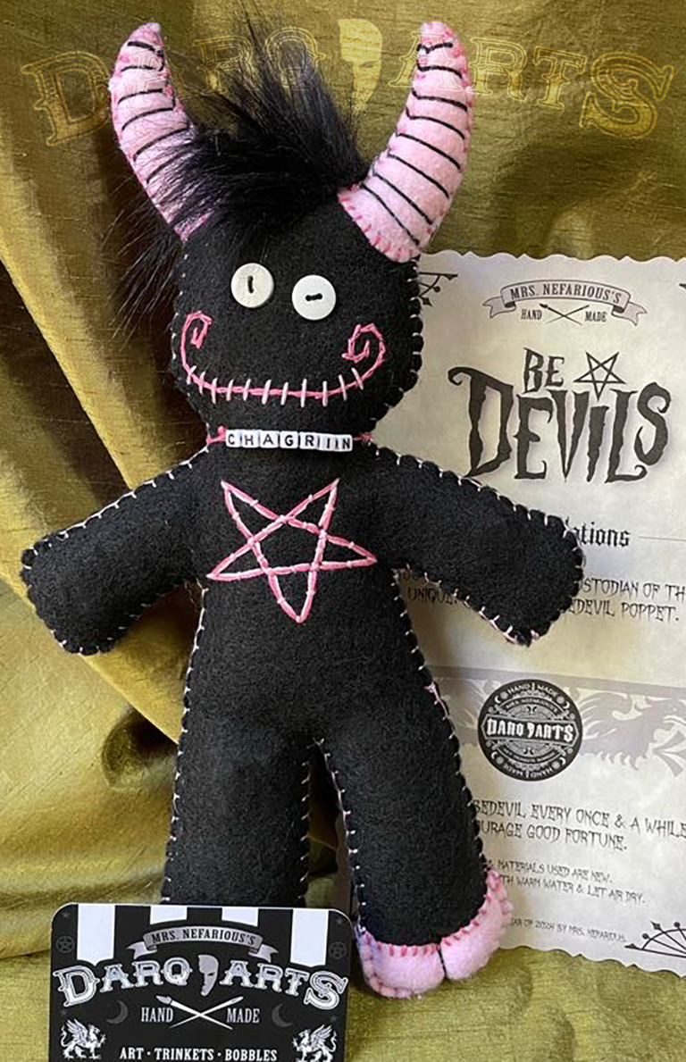 Bedevils. My name is Chagrin. I have a black felt body with piggy pink accents. Front view.