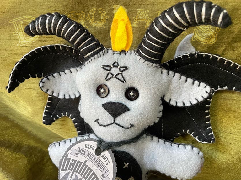 Baphomet front view close up showing adorable soft felt poppet handmade by Mrs. Nefarious of Darq.arts. Light gray body with black wings, horns and tummy. Eternal flame on top of head.