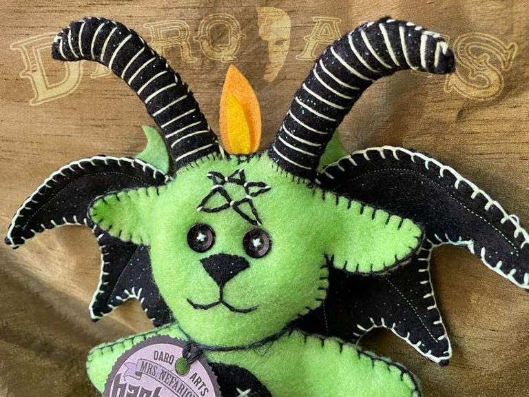 Baphomet front view close up showing adorable soft felt poppet handmade by Mrs. Nefarious of Darq.arts. Bright green body with sparkle black wings, horns and tummy. Eternal flame on top of head.
