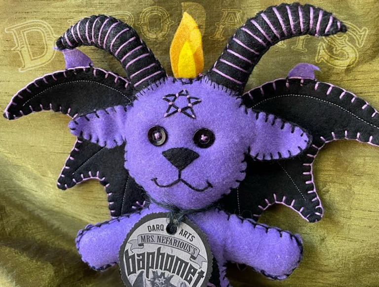Baphomet front view close up showing adorable soft felt poppet handmade by Mrs. Nefarious of Darq.arts. Purple body with black wings, horns and tummy. Eternal flame on top of head.