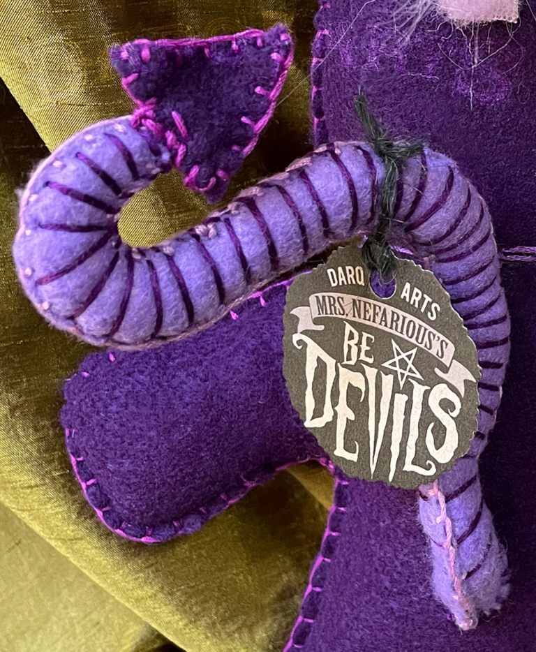 Bedevils - Scarum. Purple soft felt body with lavender horns, tail, hooves and reversed pentagram. Close up back view.