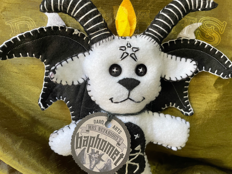 Baphomet front view close up showing adorable soft felt poppet handmade by Mrs. Nefarious of Darq.arts. Sparkle white body with black wings, horns and tummy. Eternal flame on top of head.