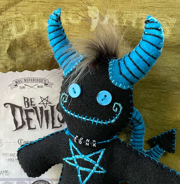 Bedevils - Zonk. Black soft felt body with cyan horns, tail, hooves and reversed pentagram. Close up of face.