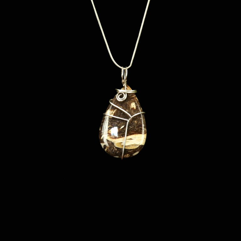 Brown and tan teardrop stone with abstract wire wrap and silver chain on black background.