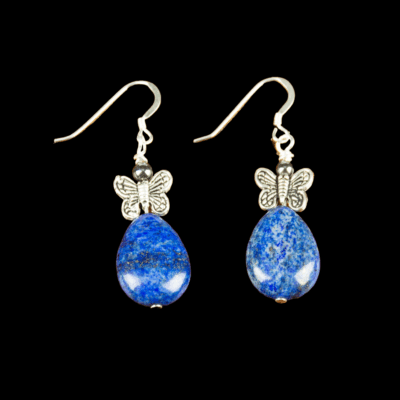 Blue lapis lazuli teardrop stone earrings. Each earring has a silver butterfly atop the teardrop shaped lapis lazuli stone. The earrings have French ear wires. These earrings are pictured on a black background.