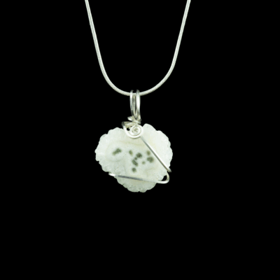 Solar Quartz stalactite slice pendant minimally wrapped in .935 Argentium Silver wire and shown on a silver snake chain on a black background. The stone is white with irregular edges and it has several green moss inclusions.