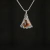 Tumbled amber stone wrapped in silver colored filigree wrap. The pendant hangs on a silver snake chain.