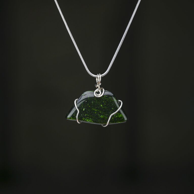 Green goldstone pendant minimally wrapped in silver craft wire. This is shown on a silver snake chain.
