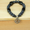Onyx and black fire agate bracelet with a silver recovery charm. Charm is a circle with a triangle in the center which traditionally represents recovery from alcohol addiction.