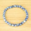 6mm blue spot jasper on a wooden background