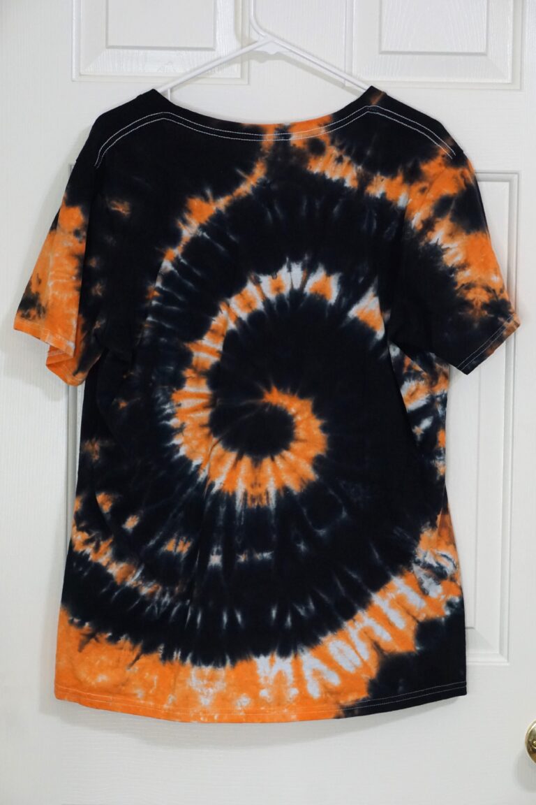 An orange and black tie-dyed V-neck shirt. Spiral pattern, XL.