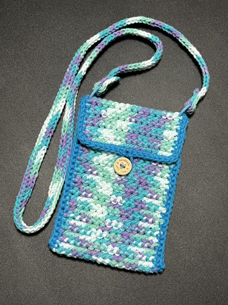 Blue/purple/white variegated cotton crossbody bag. Button closure. Shoulder strap is adjustable and removable.