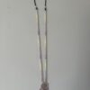 Pastel necklace hanging on wall