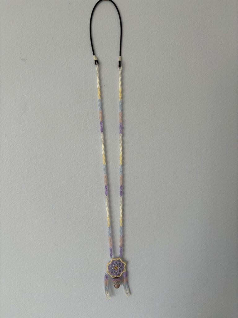 Pastel necklace hanging on wall