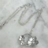 flat lay of sterling silver flower wreath pendant necklace
