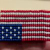 The front of the beaded distress flag pin.