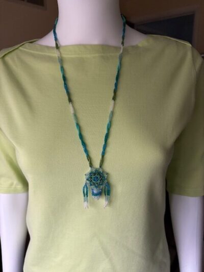 Blue lace necklace on green tee