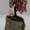 Beaded green wire tree with green, pink and red beads. On a birch base with moss and a unicorn sitting under the tree.