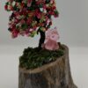 Green spring themed wire tree. With green and pink beads on a weathered birch base with moss. A small pink unicorn sits under the tree.