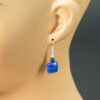 Demortierite earring hanging on the ear of a mannequin.