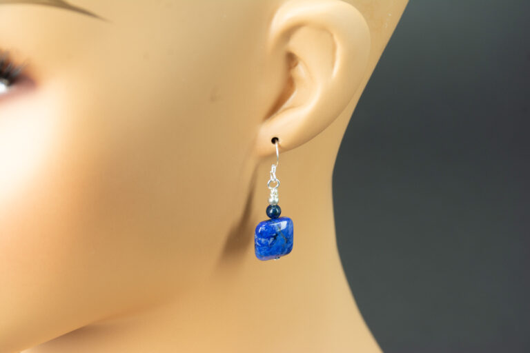 Square Dumortierite Earrings 2 Demortierite earring hanging on the ear of a mannequin.