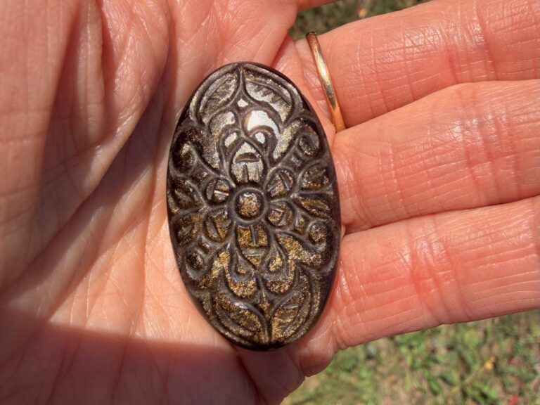 Photo of Gold Sheen Obsidian in the sunlight to show the gold sheen